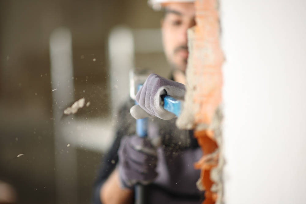 Construction,Worker,Wrecking,Wall,Using,Escarpment,And,Hammer,In,A